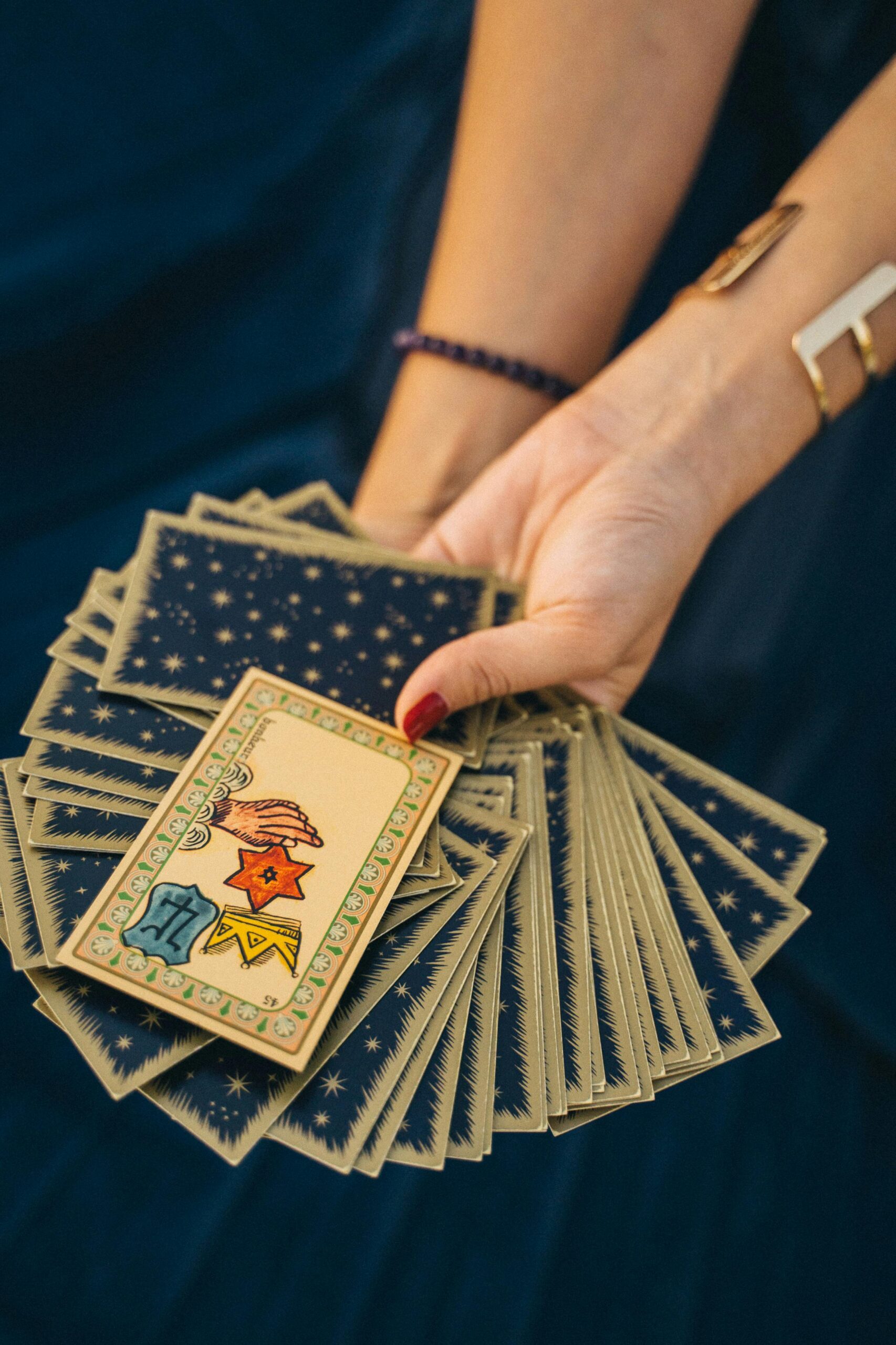 Close-up of a hand holding tarot cards, symbolizing spirituality and divination.